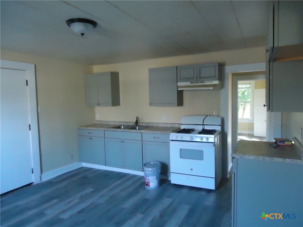 1101 South 33rd Street Temple, TX 76504 - Photo 4 of 8 a kitchen with granite countertop a stove and a wooden floors