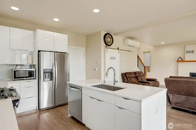 a kitchen with stainless steel appliances a refrigerator sink and microwave