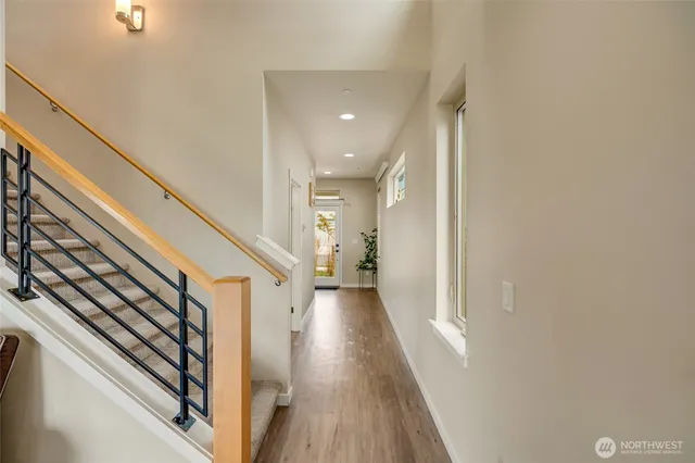 a view of a hallway with wooden floor and staircase
