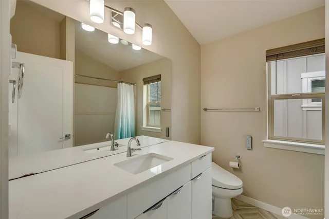 a bathroom with a sink vanity granite and toilet