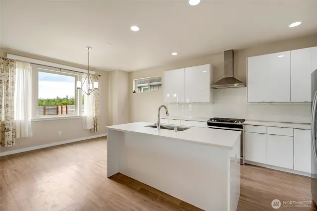 a kitchen with stainless steel appliances granite countertop a sink stove and refrigerator