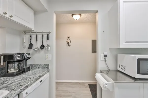 a kitchen with white cabinets and white appliances