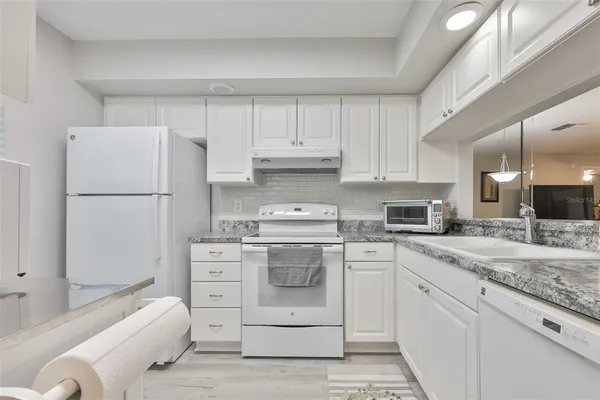 a spacious bedroom with a bed a couch and a chandelier