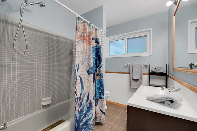 a bathroom with a sink vanity tub and shower