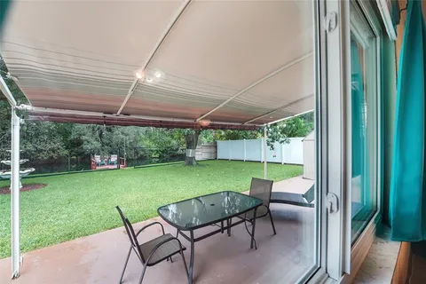 a view of a patio with table and chairs under an umbrella