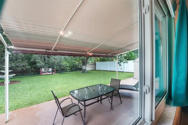a view of a patio with table and chairs under an umbrella