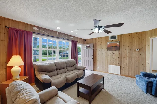 a living room with furniture a ceiling fan and a window