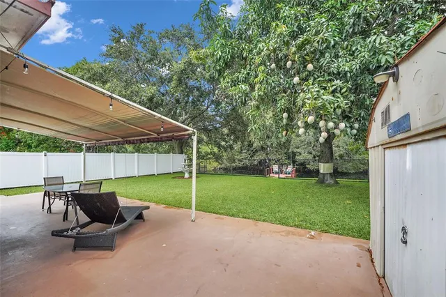 a view of a patio with table and chairs under an umbrella