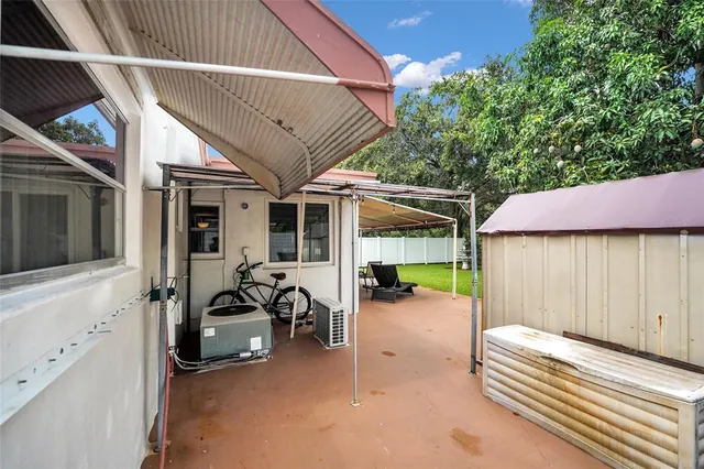 a view of a patio with a table and chairs and a barbeque