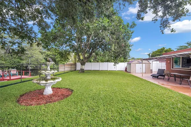 a view of a backyard with table and chairs under an umbrella
