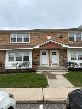 front view of a brick house with a yard