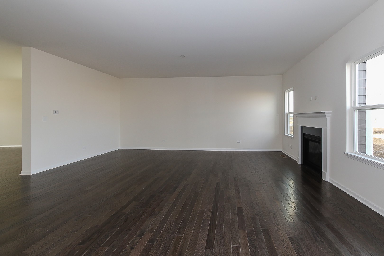 1309 Endicott Road South Elgin, IL 60177 - Photo 13 of 29 an empty room with wooden floor fireplace and windows