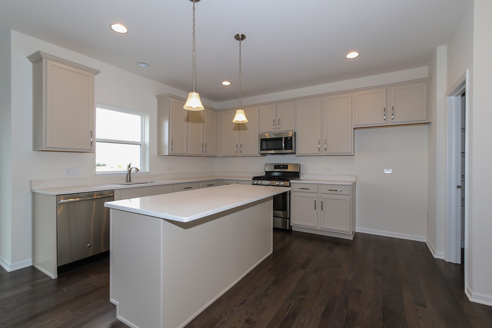 1309 Endicott Road South Elgin, IL 60177 - Photo 6 of 29 a kitchen with a stove a sink a refrigerator and white cabinets with wooden floor