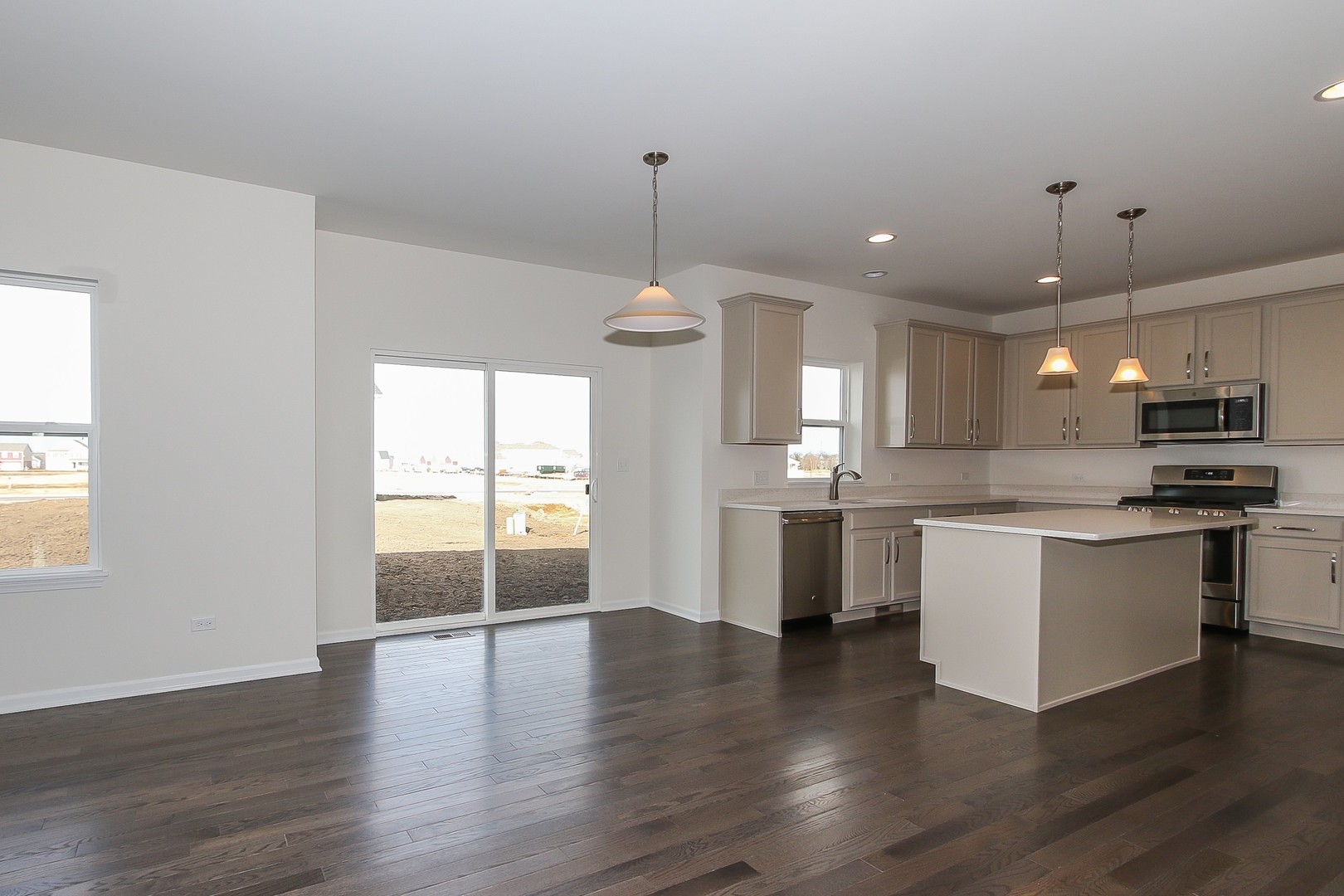 1309 Endicott Road South Elgin, IL 60177 - Photo 10 of 29 a kitchen with stainless steel appliances granite countertop a stove top oven a sink dishwasher and white cabinets with wooden floor