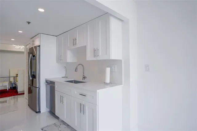 a kitchen with stainless steel appliances granite countertop a sink and a refrigerator