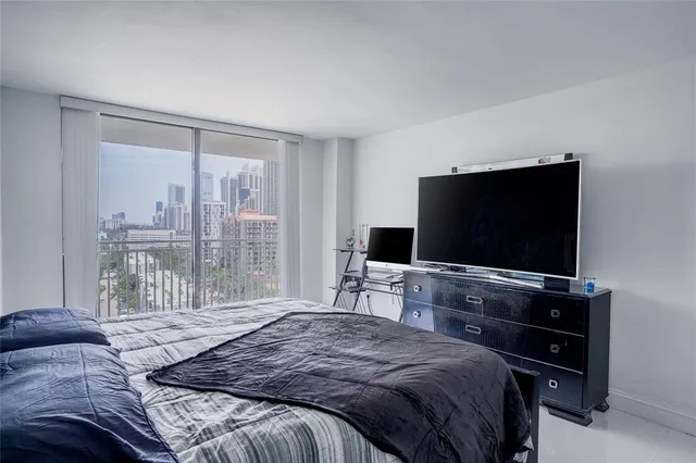 a bedroom with a bed and a flat screen tv