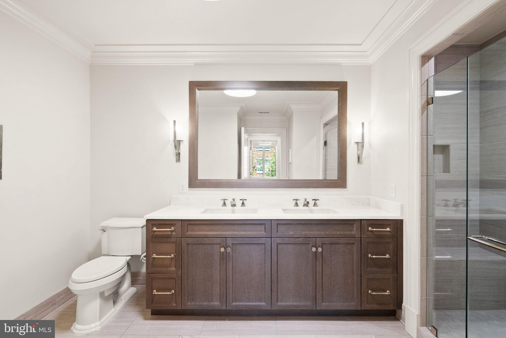 6900 Fleetwood Road, Unit 415 McLean, VA 22101 - Photo 28 of 51 a bathroom with a toilet a sink a mirror and vanity
