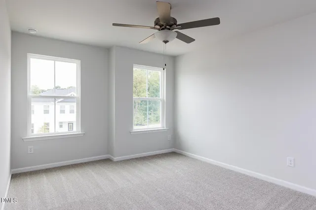 an empty room with a ceiling fan and a window