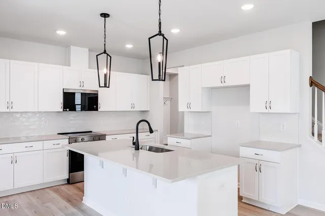 a kitchen with appliances a sink and cabinets