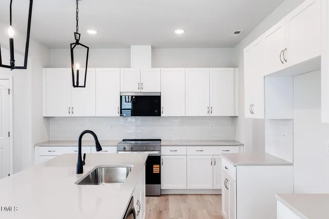 a kitchen with white cabinets and stainless steel appliances