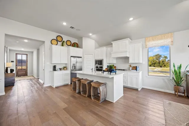a kitchen with white cabinets and white appliances