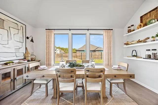a dining room with furniture and a window