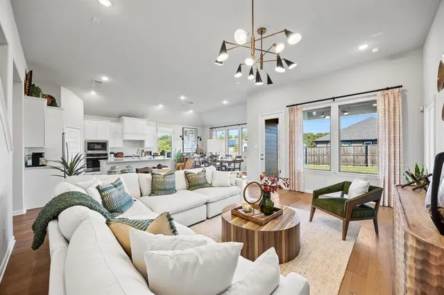 a living room with furniture kitchen and a chandelier
