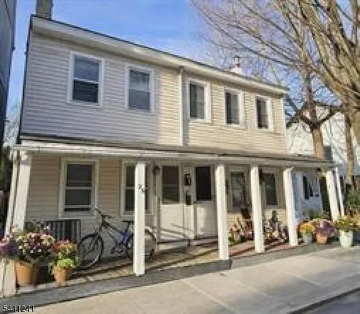 a view of a brick house with large windows and a potted plant