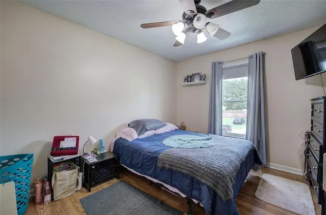 a bedroom with a bed a chandelier and a dresser