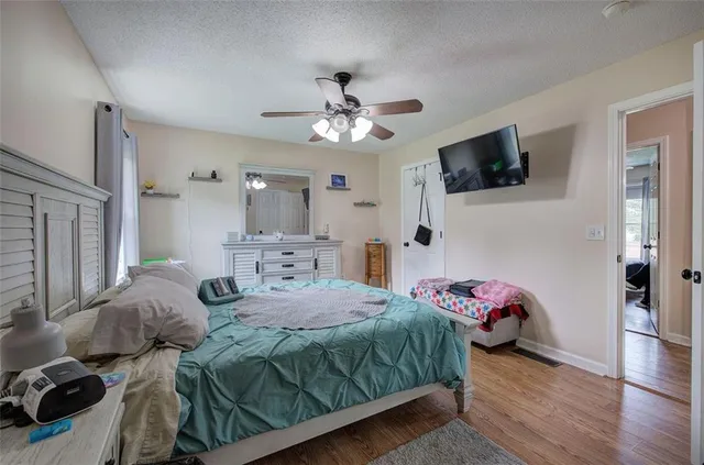 a bedroom with a bed and a flat tv screen on dresser