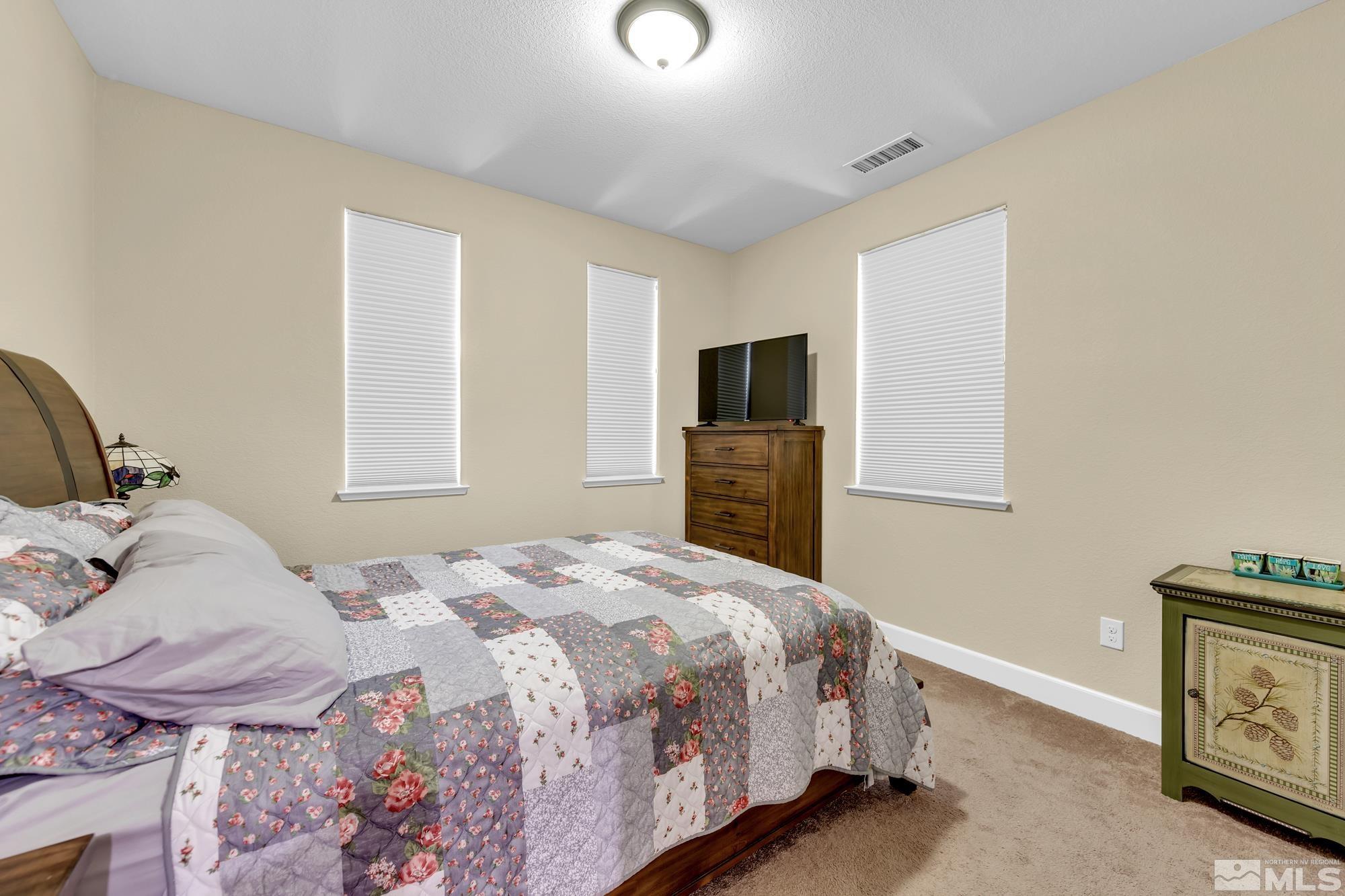 1880 Dark Horse Road, Unit A Reno, NV 89521 - Photo 13 of 20 a bedroom with a bed and a tv
