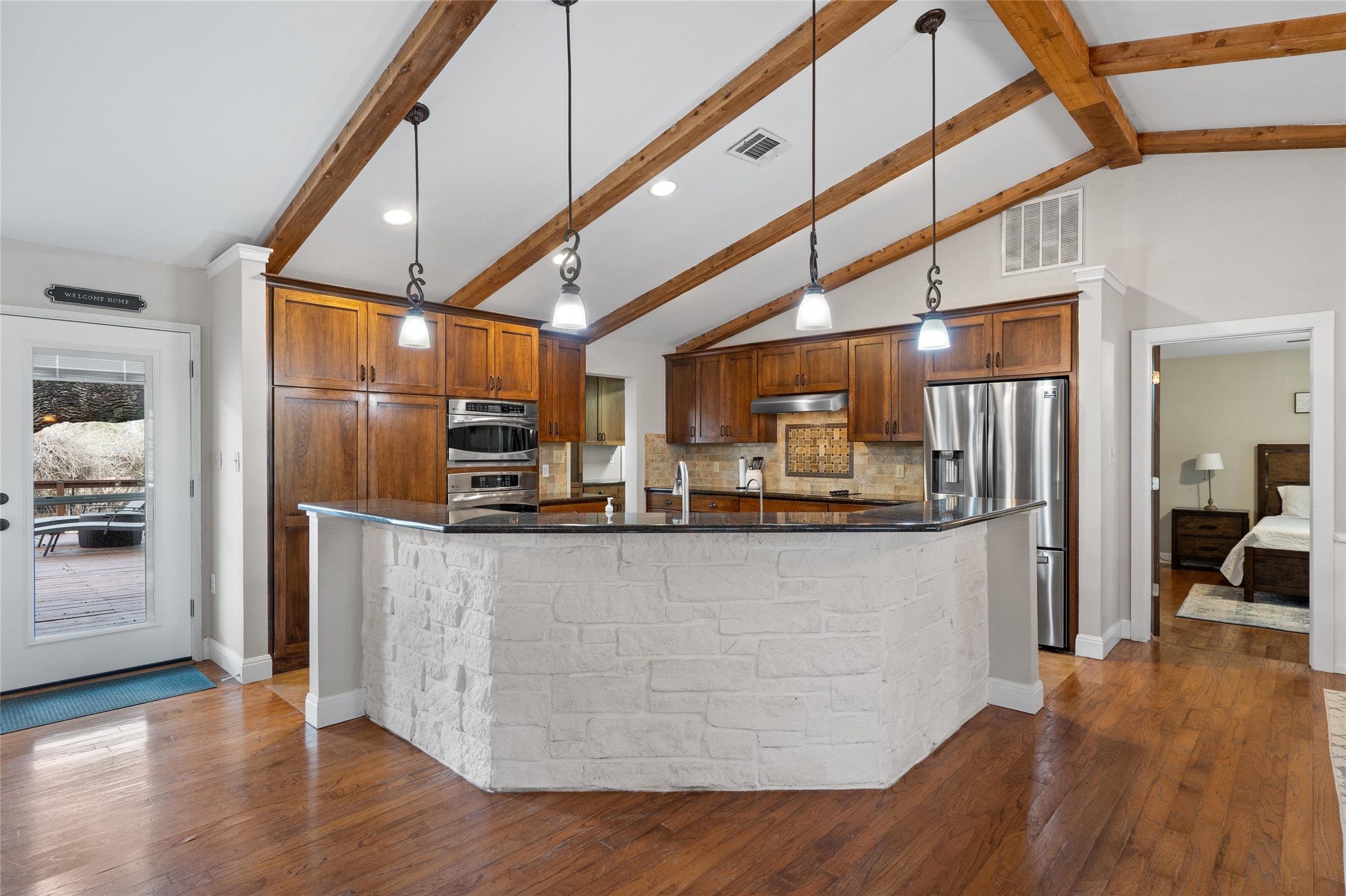 720 Circle G Ranch Road Austin, TX 78737 - Photo 11 of 37 a kitchen with stainless steel appliances granite countertop a refrigerator a sink a stove and a wooden floors