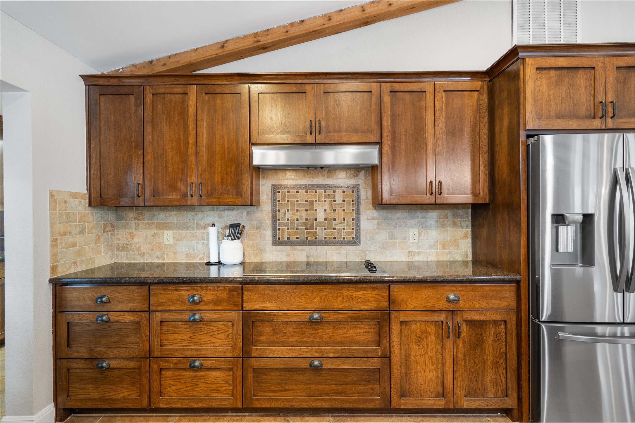720 Circle G Ranch Road Austin, TX 78737 - Photo 13 of 37 a kitchen with granite countertop wooden cabinets and refrigerator