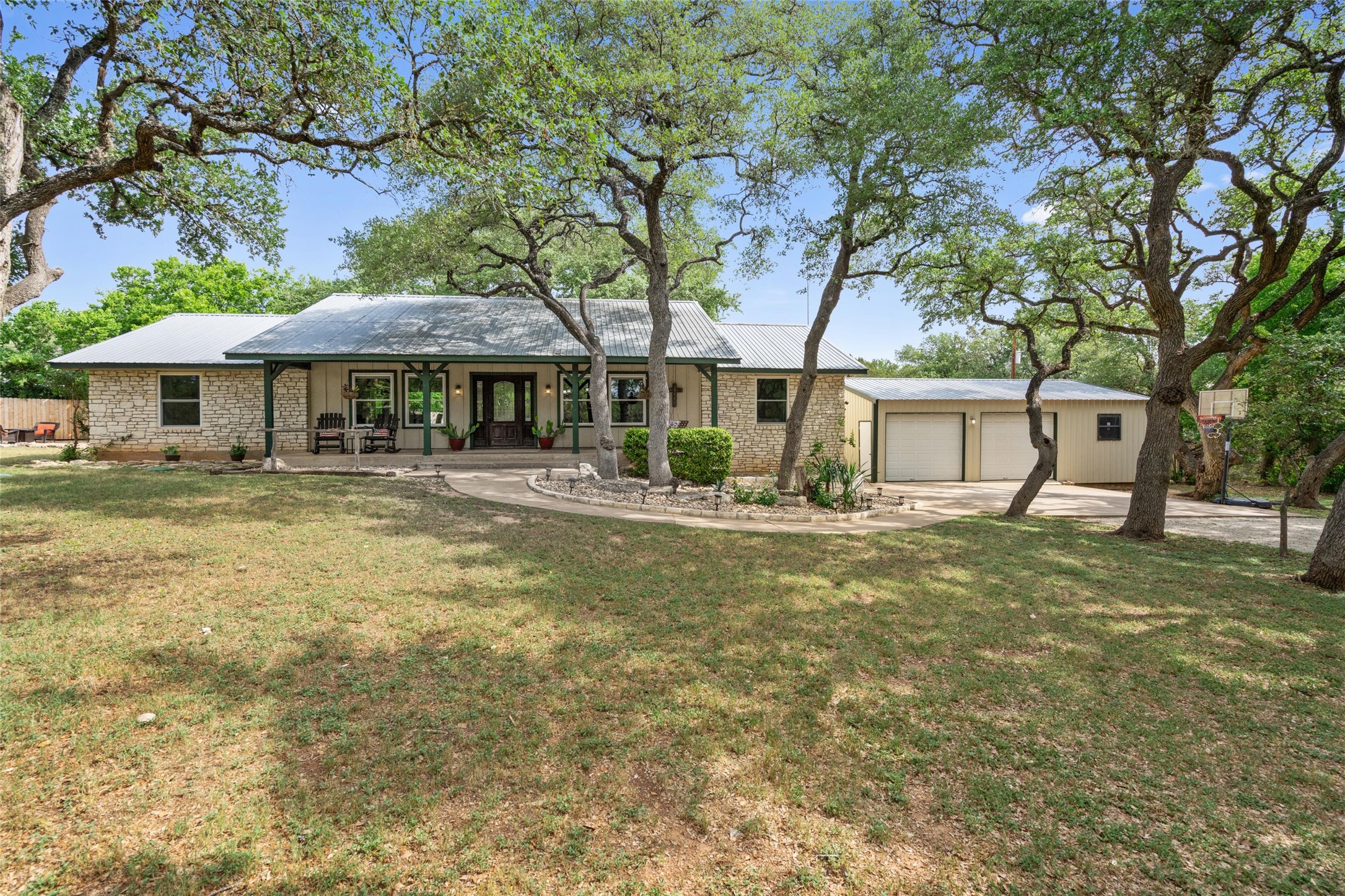 720 Circle G Ranch Road Austin, TX 78737 - Photo 3 of 37 a front view of a house with a yard table and chairs