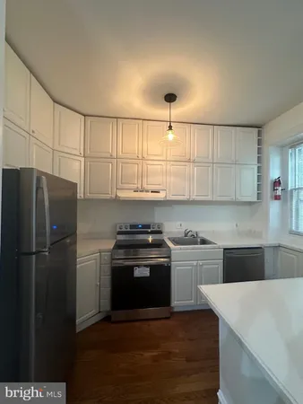 a kitchen with kitchen island a sink appliances and cabinets
