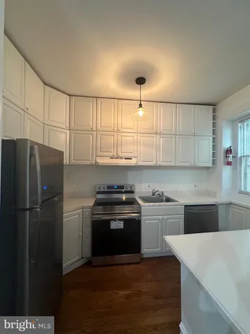 a kitchen with kitchen island a sink appliances and cabinets