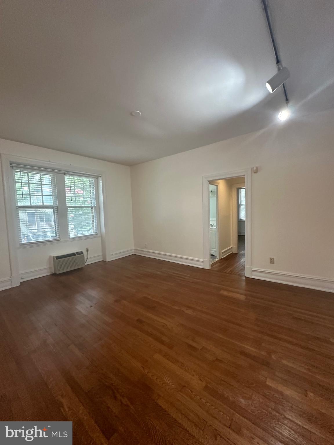 3420 16th Street Northwest, Unit 103 Washington, DC 20010 - Photo 17 of 24 an empty room with wooden floor and windows