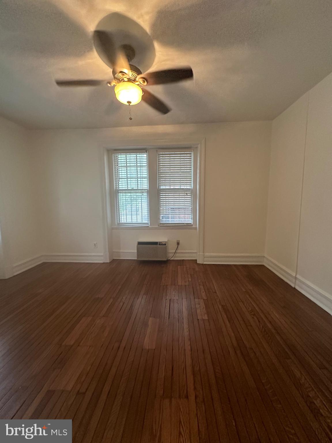 3420 16th Street Northwest, Unit 103 Washington, DC 20010 - Photo 20 of 24 a view of an empty room with wooden floor and a window