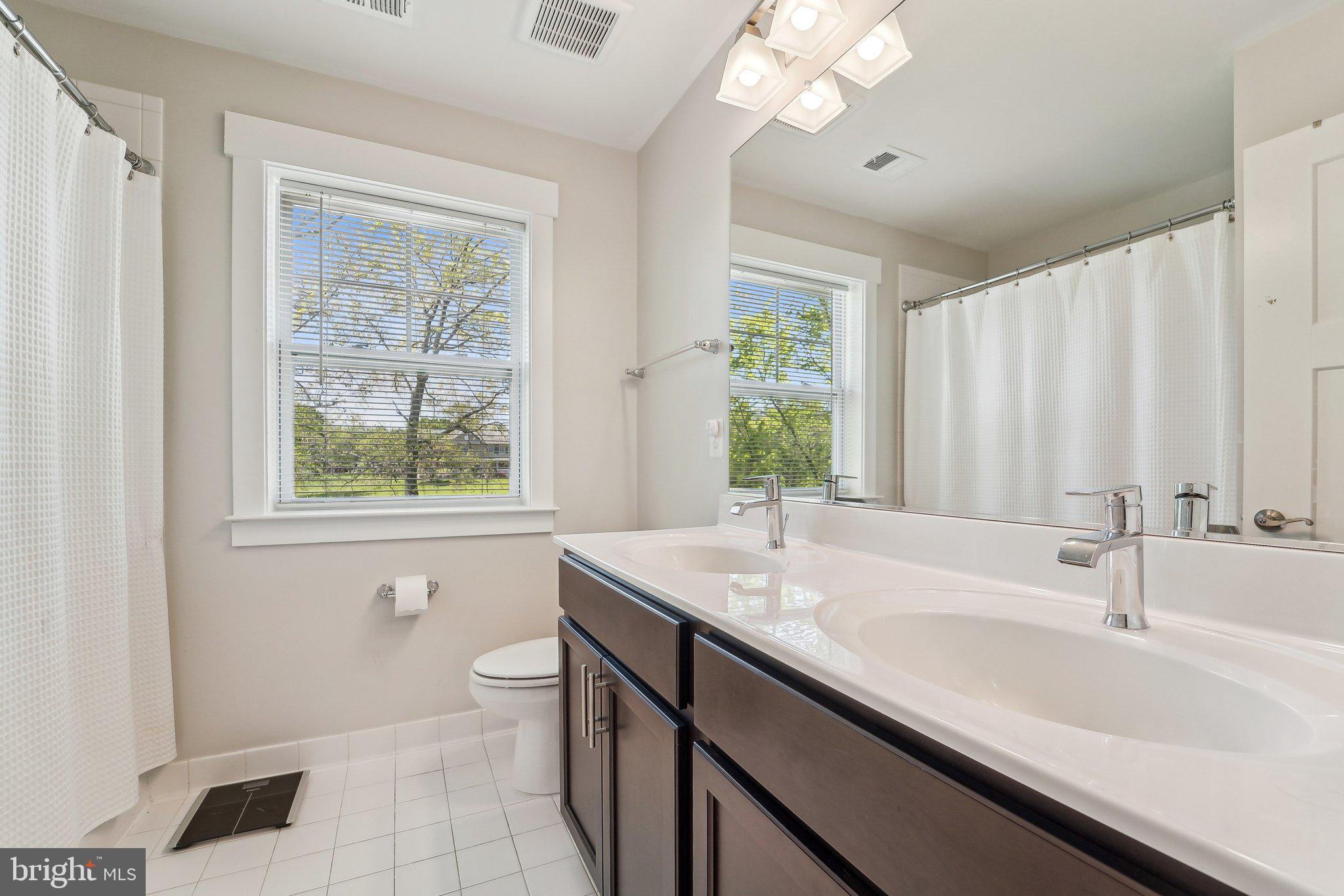 531 Highmeadow Drive Severn, MD 21144 - Photo 17 of 37 a bathroom with a granite countertop sink a toilet a large mirror and a window