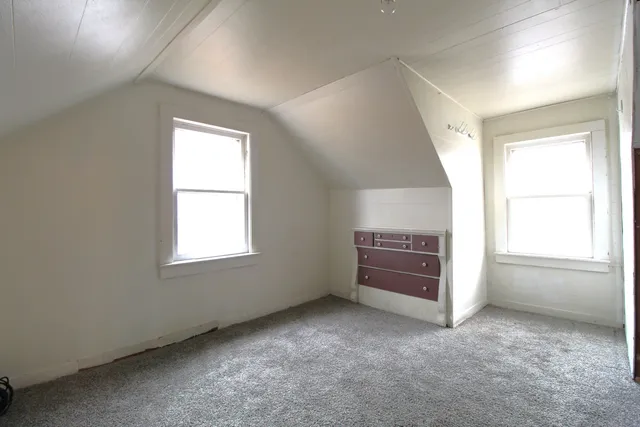 an empty room with a fireplace and window