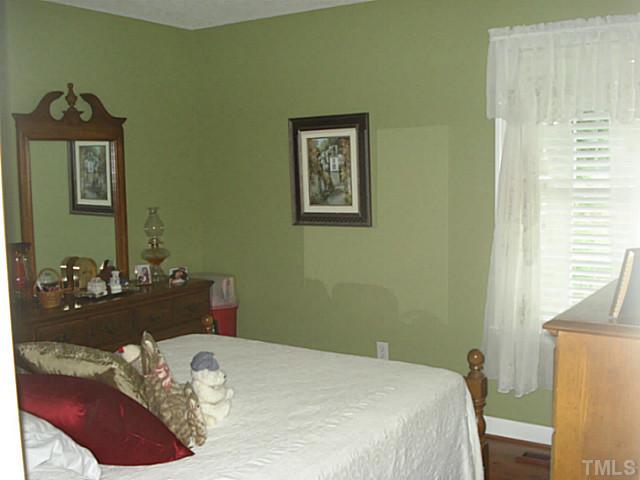 3595 Johnston County Road Angier, NC 27501 - Photo 14 of 18 a bedroom with a bed and a chandelier