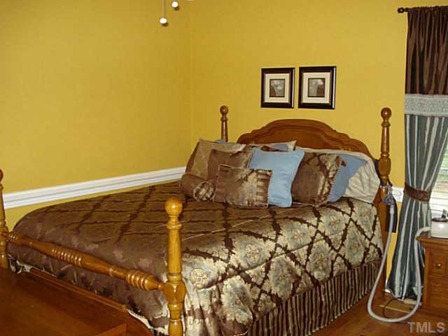 3595 Johnston County Road Angier, NC 27501 - Photo 7 of 18 a bedroom with a bed and wooden floor