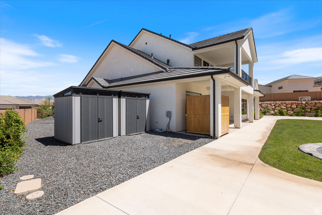 1192 East Corral Way Washington, UT 84780 - Photo 60 of 81 Rear exterior featuring a white stucco finish, dark roof tiles, and a covered patio area