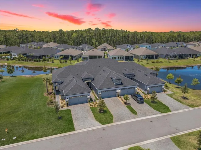 an aerial view of residential houses with outdoor space and lake view