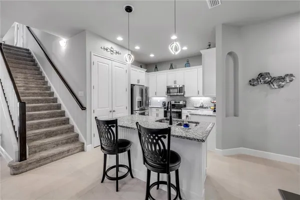 a kitchen with white cabinets and sink
