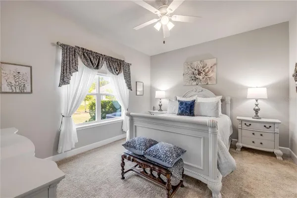 a spacious bedroom with a bed and a chandelier