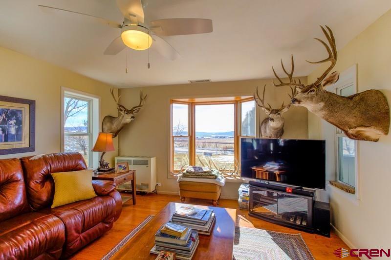 3115 Cr 973 Ignacio, CO 81137 - Photo 24 of 45 a living room with furniture a flat screen tv and a floor to ceiling window
