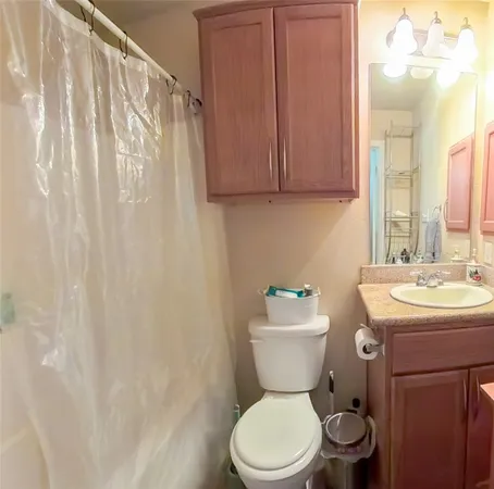 a bathroom with a toilet a sink and a shower curtain