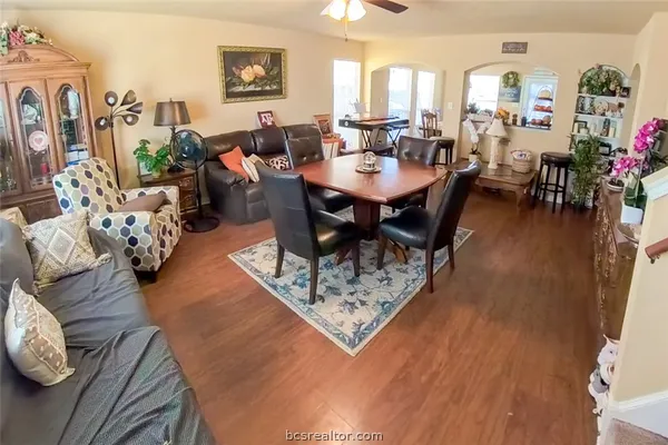 a living room with lots of furniture a rug potted plant and a large window