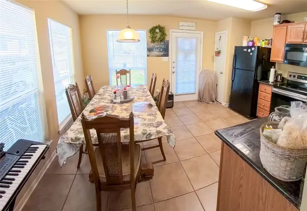 a dining room with furniture and a floor to ceiling window